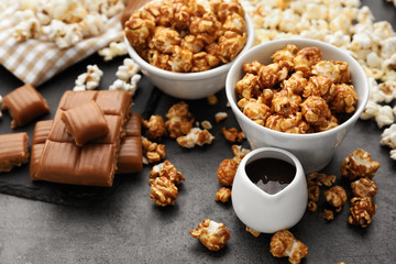 Bowls with delicious caramel popcorn on grey table