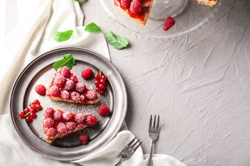 Plate with pieces of delicious raspberry cheesecake on table