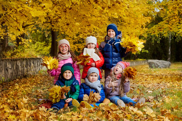 Fototapeta premium Happy children play in the autumn in a park.