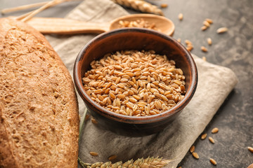 Bowl with wheat grains on table