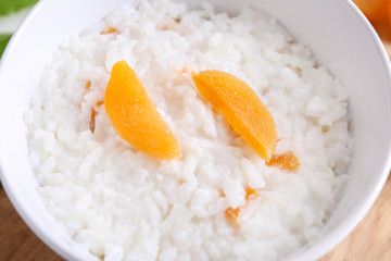 Bowl with delicious rice pudding and dried apricot, closeup