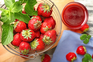 Bowls with delicious jam and strawberries on table
