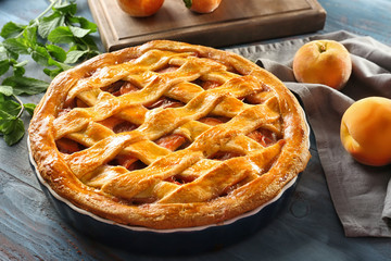 Delicious peach pie on wooden table