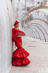 Woman dressed in red dancing flamenco with red fan - obrazy, fototapety, plakaty