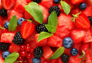 Salad with delicious watermelon and berries as background