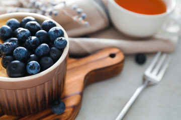 Bowl with delicious blueberry pudding on light table, closeup
