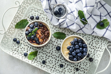 Bowls with delicious blueberry pudding on tray