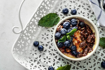 Bowl with delicious blueberry pudding on tray