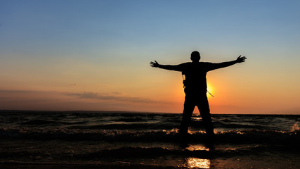 silhouette of a man at dawn / beach wilderness dawn