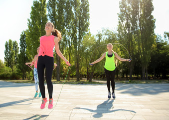 Group of sporty people jumping rope outdoors