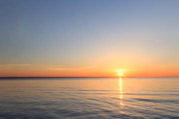 Fototapeta premium sunrise on the water / Early summer morning bright sky Beach