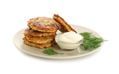 Plate with zucchini pancakes and sauce isolated on white