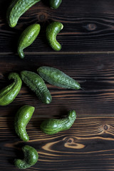 Fresh green cucumber with flowering dill on a wooden background