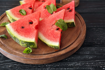 Board with delicious cut watermelon on wooden table