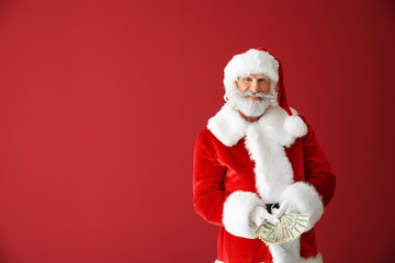 Fototapeta na wymiar Santa Claus with money on color background