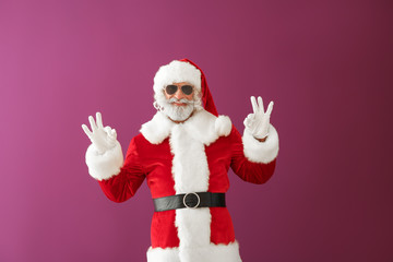 Fototapeta na wymiar Cool Santa Claus showing OK gesture on color background