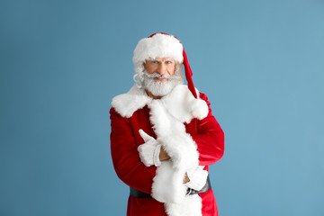 Fototapeta na wymiar Portrait of Santa Claus on color background