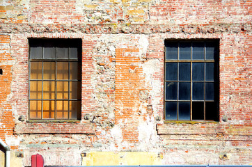 Fototapeta na wymiar historic building in stone and bricks with old windows
