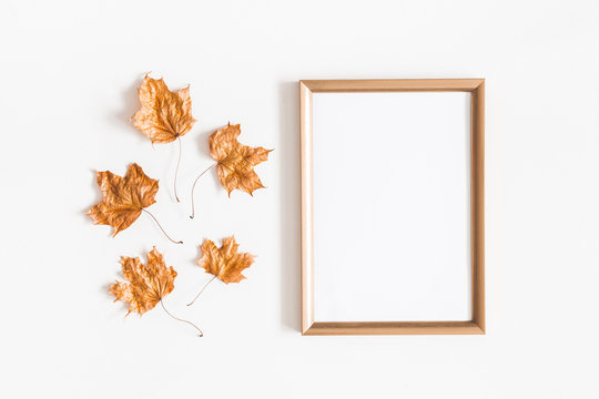 Autumn composition. Golden leaves, photo frame on white background. Autumn, fall concept. Flat lay, top view, copy space
