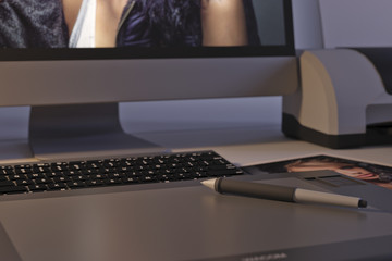 Office desk with Wacom tablet, pen, Apple monitor and photograph of a beautiful woman