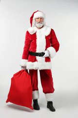 Portrait of Santa Claus with bag full of gifts on white background