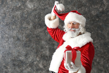 Santa Claus with gift box on dark background