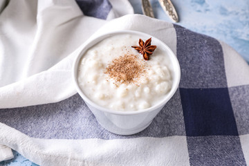 Delicious rice pudding with cinnamon and anise in bowl on table