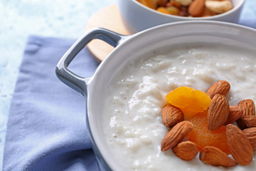 Delicious rice pudding with dried apricots and almonds in casserole, closeup