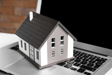 House model on laptop. Mortgage concept