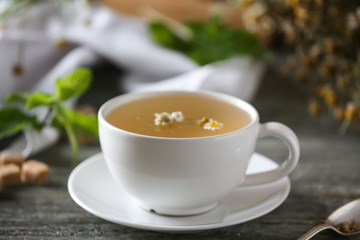 Cup of delicious chamomile tea on wooden table