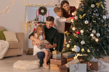 Happy family near Christmas tree in room