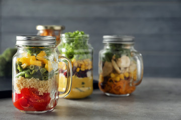 Delicious vegetable salad in mason jar on grey table