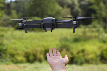 The girl catches the quadcopter outdoors after the flight