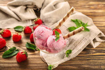 Dessert bowl with delicious strawberry ice-cream on wooden background