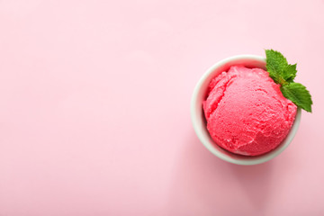 Bowl with delicious strawberry ice-cream on color background