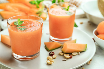 Glasses with delicious melon smoothie on plate, closeup
