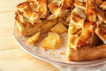 Plate with delicious apple pie on wooden table, closeup