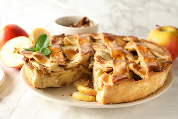 Plate with delicious apple pie on white table, closeup