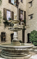 Patio with fountain in the old village at night, France.
