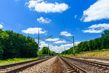 View on a railroad track and white clouds in blue sky