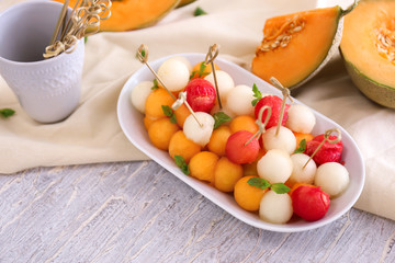 Plate with tasty melon balls on table