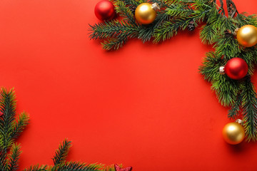Christmas tree branches and balls on color background