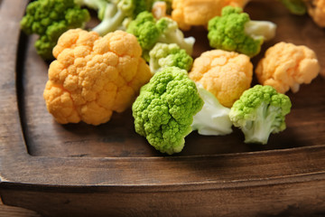Colorful cauliflowers on wooden board, closeup