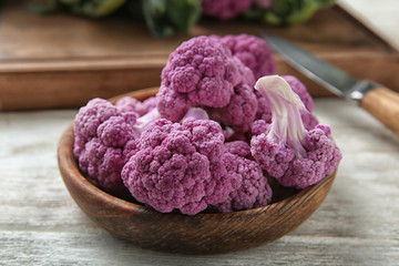 Plate with purple cauliflower on wooden table