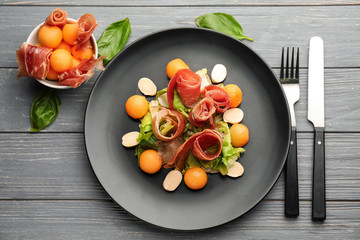 Delicious melon balls with prosciutto and mozzarella cheese on plate