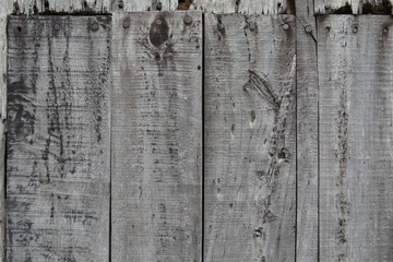 Closeup photograph of gray weathered planks in a barn gate.