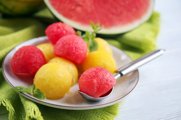 Plate with yellow and red watermelon balls on table