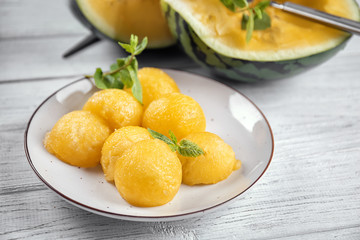 Plate with yellow watermelon balls on light table