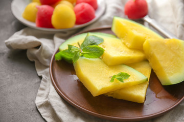 Plate with slices of yellow watermelon on dark table