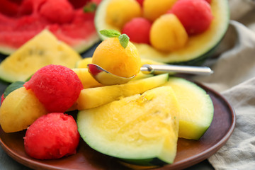Fototapeta na wymiar Slices of yellow watermelon with balls on plate, closeup